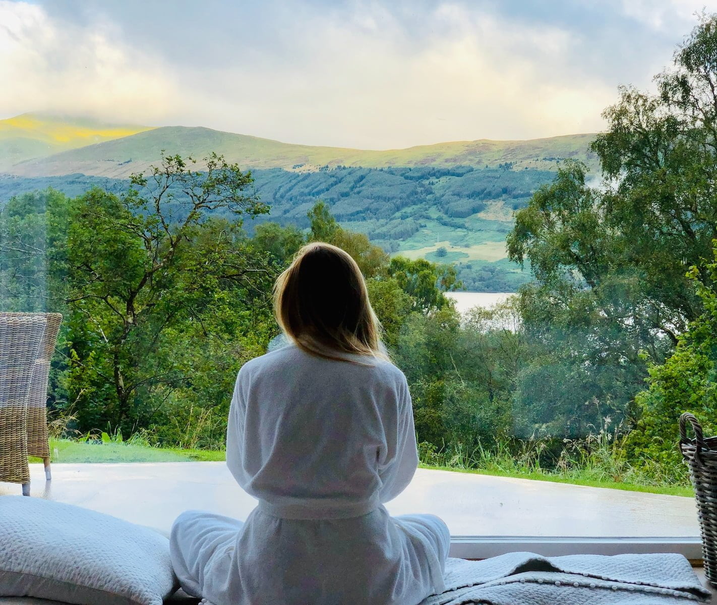 sitting woman in white robe looking at mountains during daytime