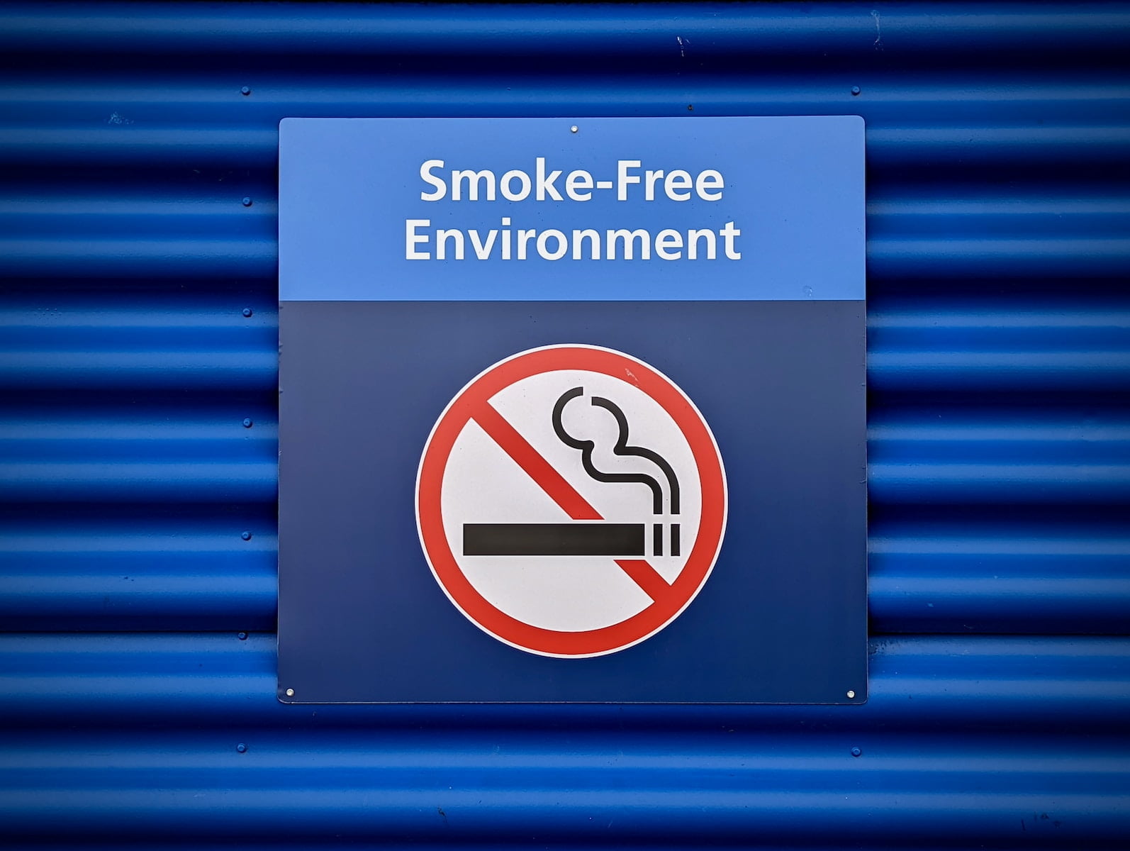 a blue sign with a no smoking sign on it