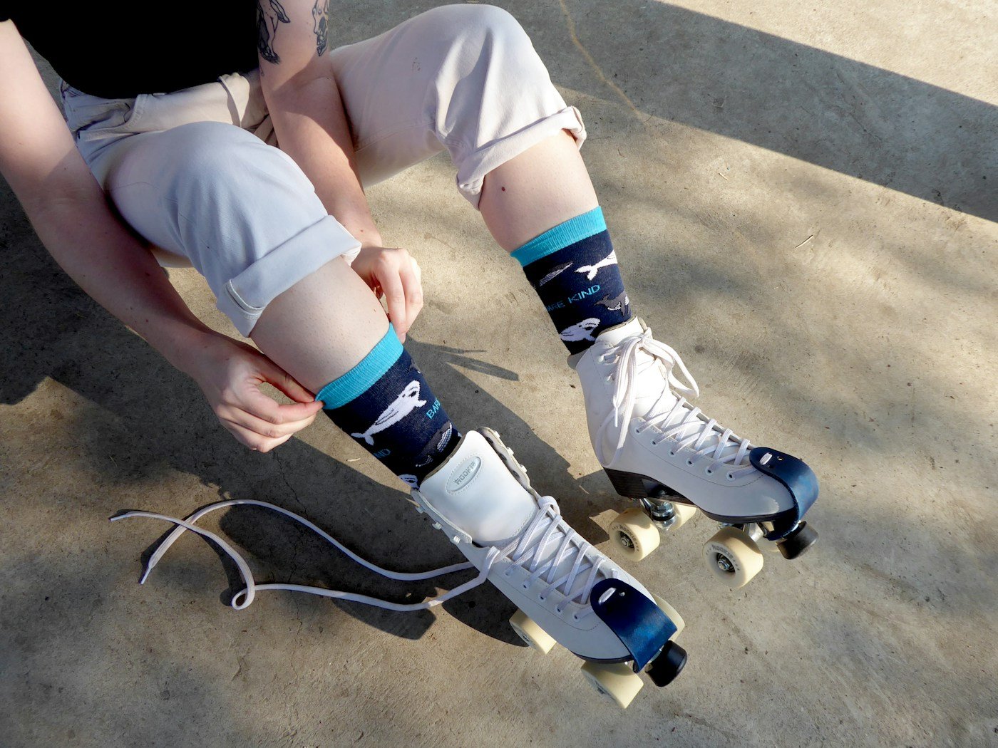 A person sitting on a ledge with their feet on a skateboard